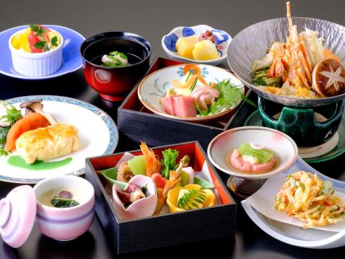 a table topped with bowls of different types of food at 湯郷グランドホテル Yunogo Onsen Yunogo Grand Hotel in Mimasaka