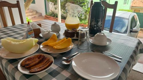 una mesa con platos de comida y una botella de zumo de naranja en Pousada da Rita en Lençóis