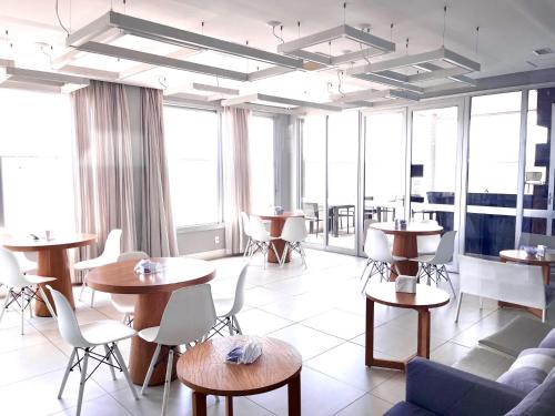 a large room with tables and chairs and windows at Flat WiseSP - Expo Anhembi in Sao Paulo