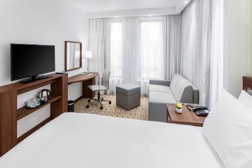 a hotel room with a bed and a television at Hampton By Hilton Gdansk Oliwa in Gdańsk