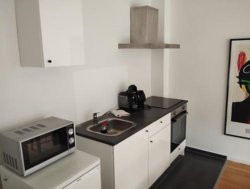 a small kitchen with a sink and a microwave at Zentrale ruhige Lage mit Parkplatz und Terrasse in Bad Honnef am Rhein