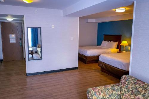 a hotel room with two beds and a mirror at Quality Inn in Ottawa