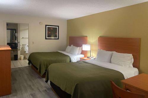 チーフランドにあるQuality Inn near Manatee Springs State Parkのベッド2台とキッチンが備わるホテルルームです。