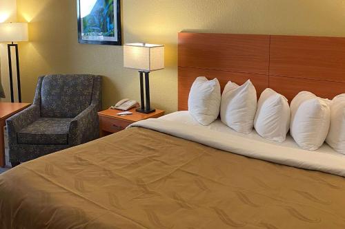 a hotel room with a bed and a chair at Quality Inn near Manatee Springs State Park in Chiefland
