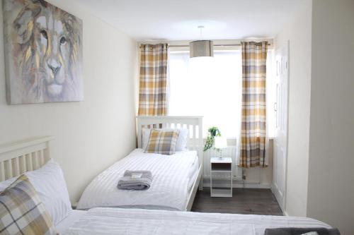a bedroom with two beds and a window at Exquisite Stays Free parking, fast WiFi, close to city centre in Kenton