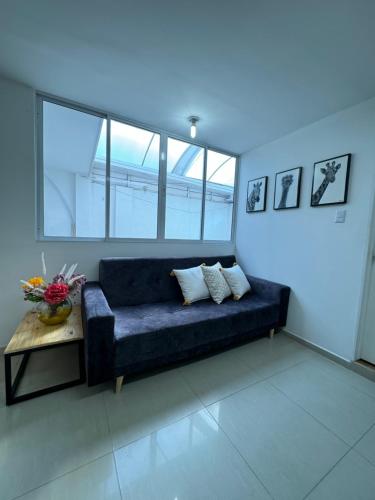 a living room with a blue couch and a table at Apto estudio con parqueadero y wifi. in Yopal
