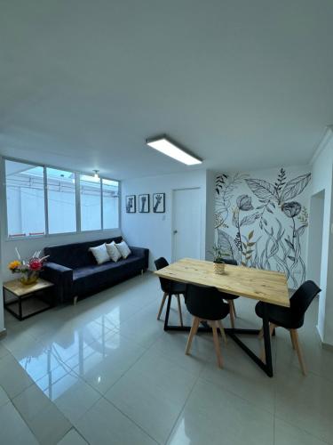 a living room with a table and a couch at Apto estudio con parqueadero y wifi. in Yopal