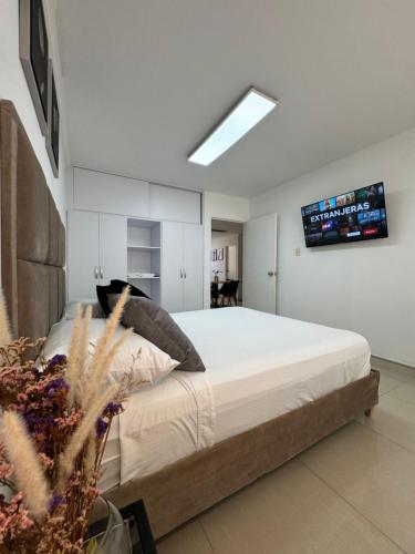 a bedroom with a bed with a television on the wall at Apto estudio con parqueadero y wifi. in Yopal