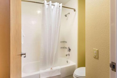 a bathroom with a shower with a toilet and a shower curtain at Comfort Inn DeKalb - Adjacent the University in DeKalb