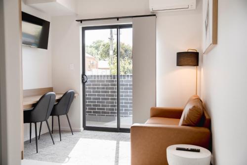 a living room with a couch and a table at Amica Serviced Apartments in Orange
