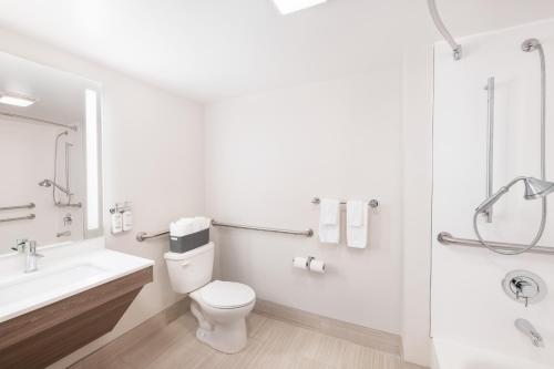 a white bathroom with a toilet and a sink at Holiday Inn Express Atlanta West - Theme Park Area by IHG in Lithia Springs