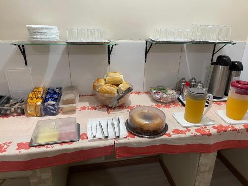 eine Küchentheke mit einem Tisch mit Speisen und Getränken in der Unterkunft Hotel Puma in São Paulo