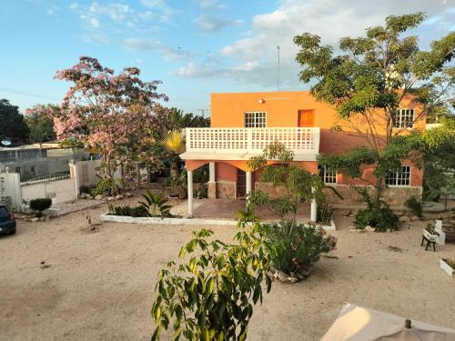 an orange house with trees in front of it at Casa en VILLA GABRIELA in Celestún