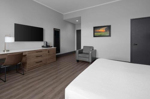 a hotel room with a bed and a desk and a chair at The Oread Lawrence, Tapestry Collection by Hilton in Lawrence