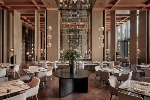 un ristorante con tavoli e sedie e una stanza con finestre di Conrad Shenzhen, Complimentary mini-bar for first round a Shenzhen