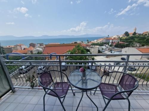 a glass table and two chairs on a balcony at Apartments by the sea Gradac, Makarska - 22460 in Gradac