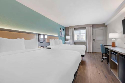 a hotel room with two beds and a desk at Comfort Inn Sea World Area in San Diego