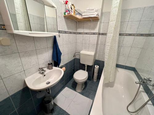 a bathroom with a sink and a toilet and a tub at Apartments with a parking space Kastel Luksic, Kastela - 22593 in Kaštela