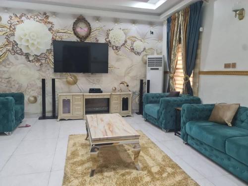 a living room with blue couches and a tv at Prime PH Home in Port Harcourt