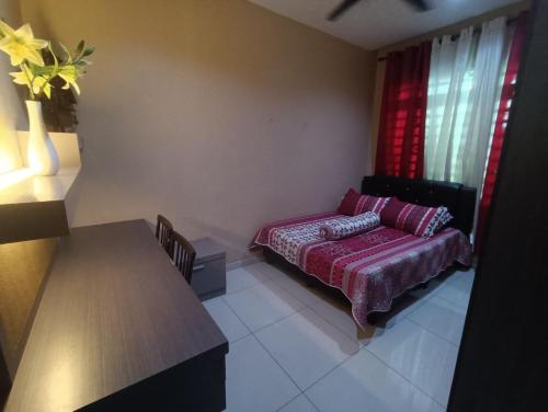 a bedroom with a bed and a table and window at AYRA HOMESTAY in Kuala Kangsar