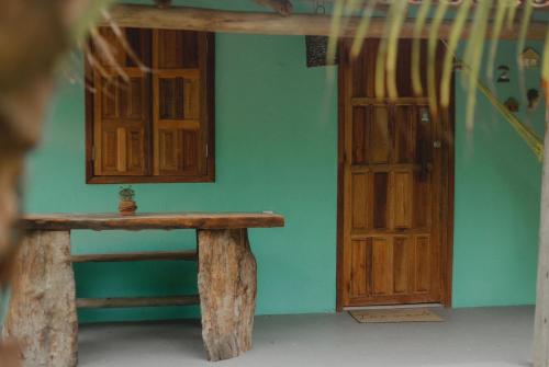 Habitación con banco de madera junto a una puerta en Casa 02 na villa uryah en Caraíva