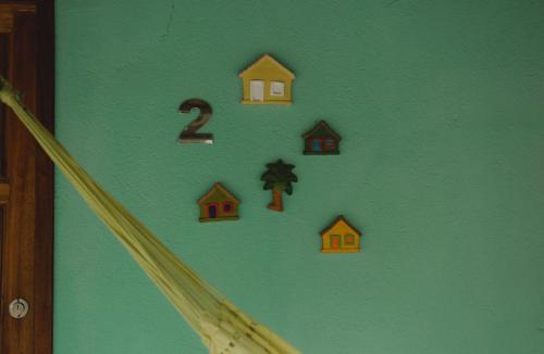 a green wall with houses and numbers on it at Casa 02 na villa uryah in Caraíva
