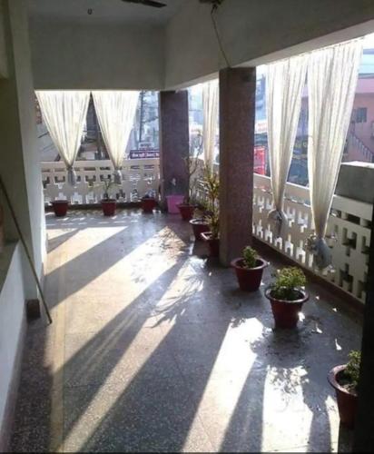 un pasillo con macetas y ventanas en un edificio en International Hotel In, en Gorakhpur