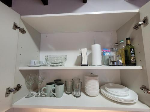 a cupboard with plates and glasses and wine bottles at Moderno departamento en Godoy Cruz in Godoy Cruz