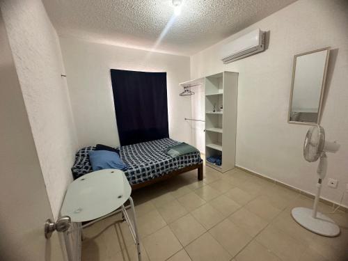 1 dormitorio con 1 cama y 1 silla en una habitación en Departamento playa del carmen, en Playa del Carmen