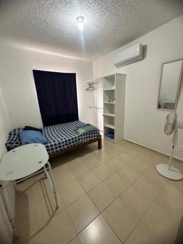 Habitación con cama, silla y teléfono en Departamento playa del carmen, en Playa del Carmen