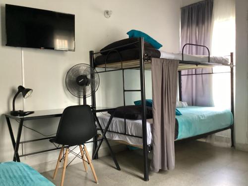 1 Schlafzimmer mit 2 Etagenbetten und einem Schreibtisch in der Unterkunft Hostel Cocoon la 70 in Medellín