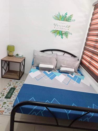 a bedroom with a bed with a blue comforter at Honeydew Transient House in Mabiga