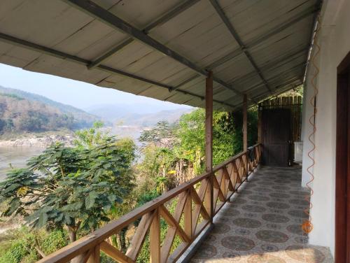 a balcony of a house with a view of a river at Dorm Riverside in Pakbeng