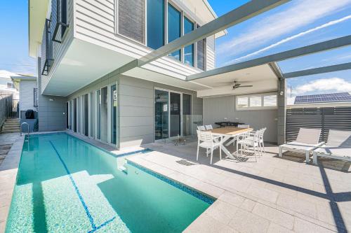 a house with a swimming pool with a table and chairs at Pacific House in Crescent Head