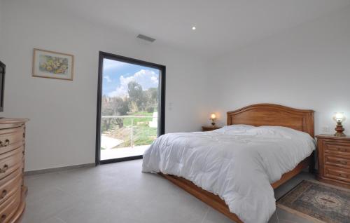 ein Schlafzimmer mit einem Bett und einem großen Fenster in der Unterkunft Stunning Home In Vence With Kitchen in Vence