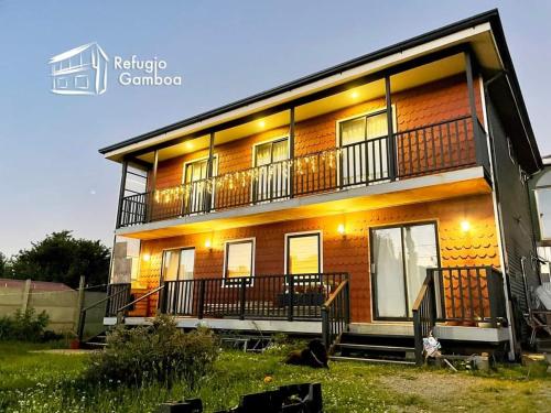 a house with a balcony on the side of it at REFUGIO GAMBOA in Castro