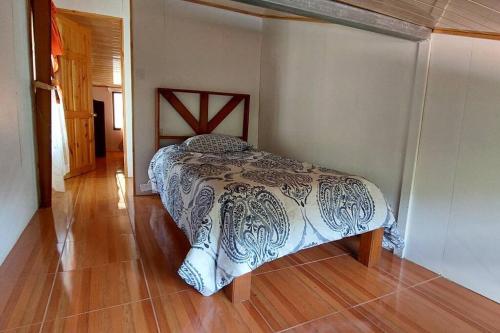 a bedroom with a bed in the corner of a room at Villa El Sol in Jardín