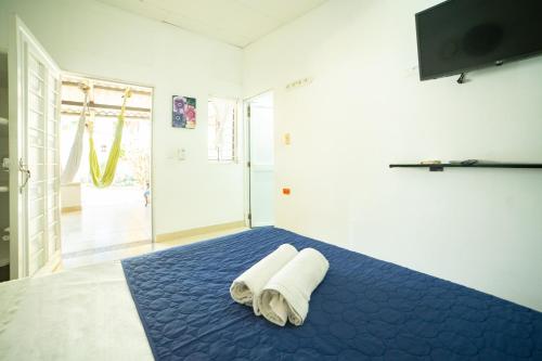 Un dormitorio con una cama azul con toallas. en Hostal del Mar - Tolu en Tolú