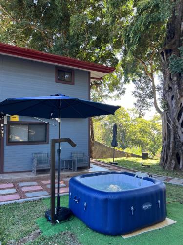 a large blue pool with an umbrella next to a house at Villazul 1 in Poás