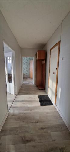 un corridoio vuoto di una casa vuota con una porta di Двухкомнатная квартира на юго-востоке г.Караганда a Karagandy