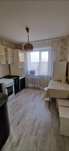 cocina vacía y sala de estar con ventana grande en Двухкомнатная квартира на юго-востоке г.Караганда, en Karagandá