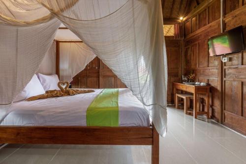 a bedroom with a bed with a mosquito net at Desaku Bungalows in Canggu