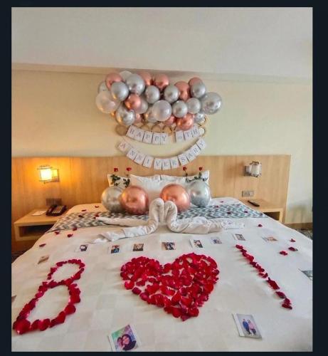 a group of people laying on a bed with hearts at Louis Kienne Hotel Simpang Lima in Semarang