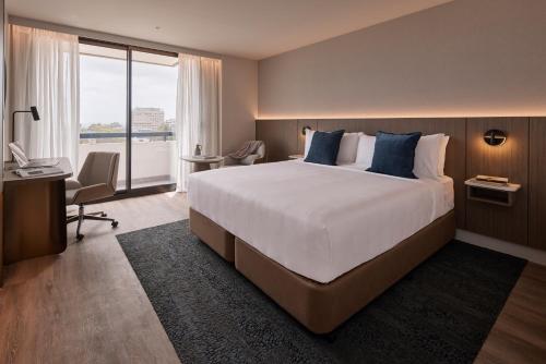 una camera d'albergo con un grande letto e una scrivania di The Miller Hotel North Sydney a Sydney