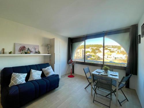 un salon avec un canapé bleu et une table dans l'établissement Studio cabine 3 pers. avec parking, à 450 m des plages - FR-1-338-420, à Sète