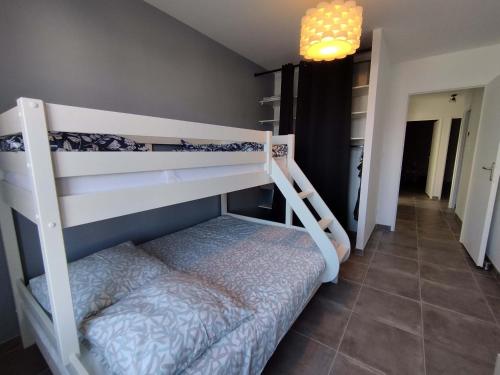 une chambre avec deux lits superposés dans une pièce dans l'établissement Maison lumineuse 3 ch avec jardin, 600m plage, WiFi, parking, 6 pers – Saint-Denis-d'Oléron - FR-1-778-16, à Saint-Denis-dʼOléron