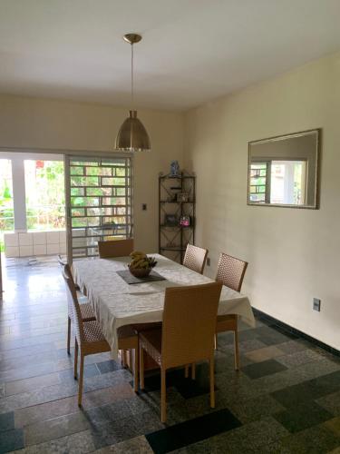 ein Esszimmer mit einem Tisch und Stühlen in einem Raum in der Unterkunft Mini chácara dentro da cidade in Caldas Novas
