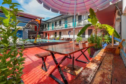 einen Holztisch auf einer Terrasse mit Sonnenschirm in der Unterkunft Capitanos in Darwin