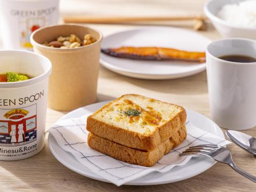 a table with plates of toast and a cup of coffee at Tokyu Stay Nishi Shinjuku in Tokyo