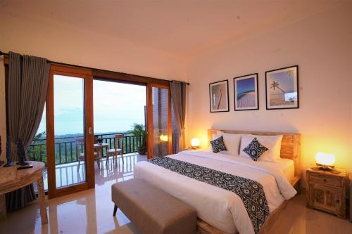 een slaapkamer met een groot bed en een balkon bij Mere Sea View Resort & Spa in Batununggul
